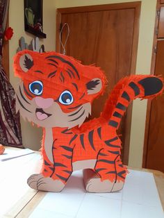 a paper cut out of a tiger standing on top of a white counter next to a wooden door