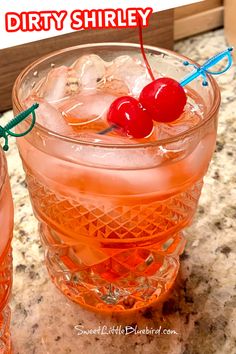 two glasses filled with drinks sitting on top of a counter