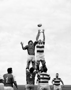 four men jumping up to catch a football