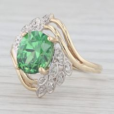 Gemstone Information: - Cubic Zirconia - Carats - 3.80ct  Cut - Oval Brilliant Color - Light Green Please note there is a bit of wear to the surface of the cubic zirconia. - Natural Diamonds - Total Carats - 0.04ctw Cut - Single Color - F - H Clarity - SI2 - I1 Metal: 10k Yellow Gold Weight: 4.5 Grams  Stamps: 10kp (P is for Plumb for high quality gold) Face Height: 18 mm  Rise Above Finger: 9.1 mm Band / Shank Width: 2 mm This ring is a size 6 1/2, but it can be resized down 2 sizes for a $20 fee or up 3 sizes for a $25 fee. If you would like your ring resized, please select the appropriate fee from the listing below in order to pay the sizing fee: https://www.etsy.com/listing/781388346/ring-sizing-service-fee Each piece is thoroughly examined and refinished as needed by our professional Green Oval Diamond Ring Collectible, Green Diamond Collectible Ring, Collectible Green Diamond Ring, Gold Face, Bypass Ring, Multi Stone, Multi Stone Ring, Brilliant Colors, Stone Rings