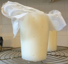 two candles sitting on top of a wire rack