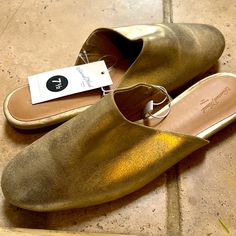 Never Worn. Casual Gold Slip-on Mules, Casual Gold Closed Toe Mules, Casual Gold Leather Mules, Casual Gold Mules With Cushioned Footbed, Casual Gold Synthetic Flats, Gold Mules With Cushioned Footbed And Round Toe, Casual Gold Slip-on Flats, Casual Gold Flats With Almond Toe, Casual Gold Almond Toe Flats