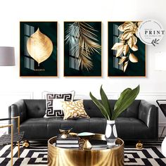 a living room with black couches and gold accents on the walls, along with three framed art prints