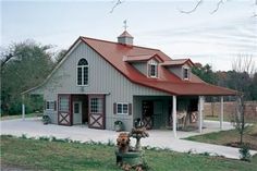 a horse is standing in front of a barn with a red roof and two stalls