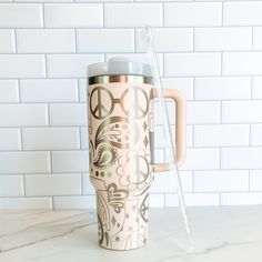 a coffee mug sitting on top of a white counter next to a plastic straw holder