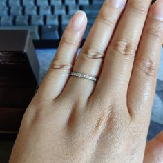 a woman's hand with a diamond ring on her left hand and a keyboard in the background