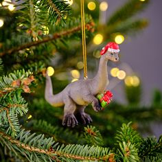 a dinosaur ornament hanging from a christmas tree