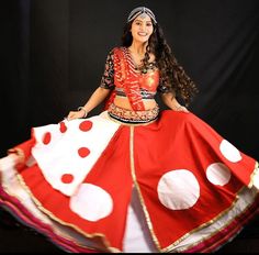 a woman wearing a red and white dress with polka dots on it, posing for the camera