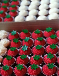 some red and white cupcakes with green leaves on them sitting next to each other