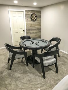 a room with a table, chairs and darts on the wall next to a door