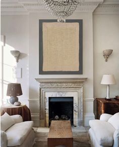 a living room filled with furniture and a fire place in front of a painting on the wall