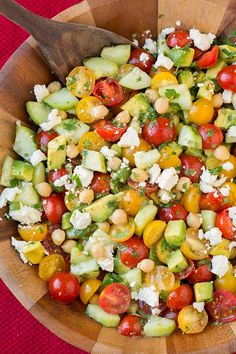 a salad with tomatoes, cucumbers, chickpeas and feta cheese