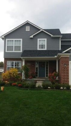 a gray house with white trim and two garages on the front porch, grass in front yard