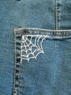 the back pocket of someone's jeans with a spider web on it