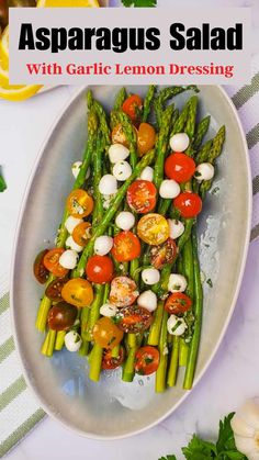 asparagus salad with garlic lemon dressing on a white plate next to fresh vegetables