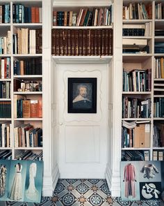 a room with bookshelves full of books and pictures