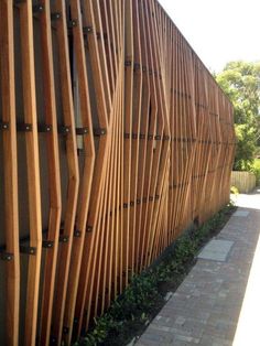 a large wooden fence on the side of a building next to a brick walk way