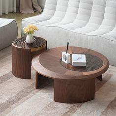 two coffee tables sitting next to each other on top of a carpeted floor in front of a white couch