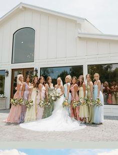 a group of women standing next to each other in front of a white building with windows