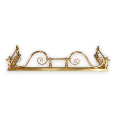 a gold metal shelf with ornate designs on the top and bottom, against a white background