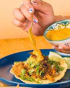 a person is dipping some sauce on top of a tortilla with other food