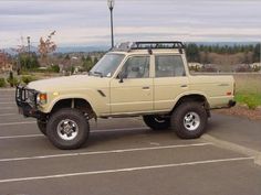 an off - road vehicle is parked in a parking lot with no one around it