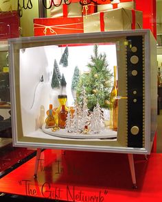 a christmas display in a store window with bottles and trees on the shelf next to it