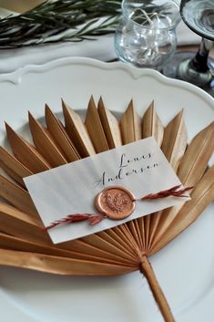 a wooden fan with a tag on it sitting on a plate next to other items