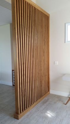 an empty room with wooden slats on the wall