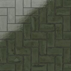 a close up view of a green brick wall with white and gray tiles on it