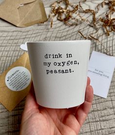 someone is holding up a cup with the words drink in my oxygen, pesant