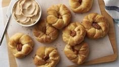 several pretzels on a cutting board with a bowl of peanut butter