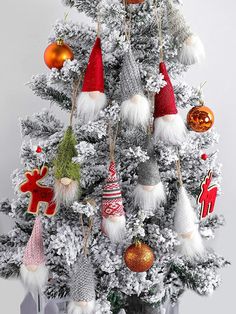 a white christmas tree with ornaments hanging from it