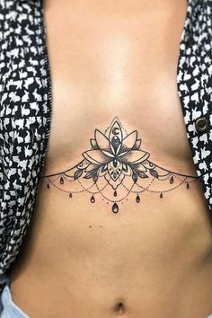 a woman's stomach with a flower tattoo on the side and an intricate design