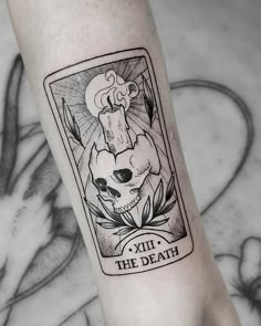 a black and white tattoo on the leg of a person with a skull in it