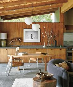 a living room filled with furniture and wooden walls