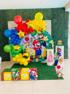 the birthday party is decorated with balloons and mario's characters, including super mario