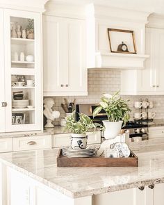 a kitchen with white cabinets and marble counter tops is displayed on the instagram page