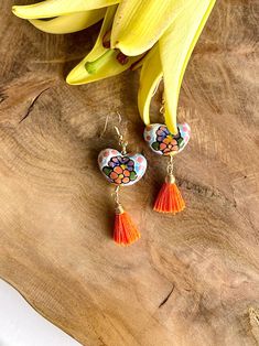 Add a touch of vibrant charm to your look with our Heart-Shaped Talavera Earrings! These stunning earrings feature intricate designs inspired by traditional Talavera pottery, accented with delightful hanging tassels in a rainbow of colors. Perfect for bringing a playful and colorful flair to any outfit. Elevate your style with these unique and eye-catching statement earrings. Gold pleated brass.Charm size: 1 inch.Total length: 2.5 inches. Traditional Heart-shaped Jewelry For Festive Occasions, Traditional Colorful Festival Earrings, Artisan Multicolor Heart Earrings, Artisan Multicolor Heart-shaped Earrings, Multicolor Latkans Earrings As Gift, Colorful Traditional Earrings, Multicolor Tassel Earrings For Gifts, Unique Multicolor Tassel Earrings For Gift, Traditional Handmade Multicolor Tassel Earrings