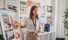 a woman standing in front of a white board with pictures on it's sides