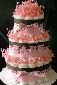 a three tiered baby shower cake with pink and brown trimmings on top