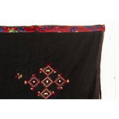 This fabulous antique Kohistani shawl whispers stories of the Mangal people, inhabiting the borderlands of eastern Afghanistan and western Pakistan. This antique shawl was Traditionally worn by women as a head covering during wedding or ceremonies, this piece is a testament to the Mangal's artistry and cultural heritage. Hand-crafted from heavy black cotton, the shawl is adorned with intricate silk embroidery. Geometric and floral motifs in vibrant colors like red, green and yellow dance across Ceremonial Shawl With Motifs, Ceremonial Shawl With Embroidered Border And Traditional Drape, Ceremonial Shawl With Embroidered Border, Bohemian Shawl With Embroidered Border For Festival, Folk Shawl With Embroidered Border, Traditional Ceremonial Dupatta Shawl, Traditional Dupatta Shawl With Border, Traditional Dupatta With Border In Shawl Shape, Traditional Shawl Shaped Dupatta With Border