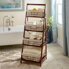 a bathroom with a bathtub, towel rack and rug on the floor in front of it