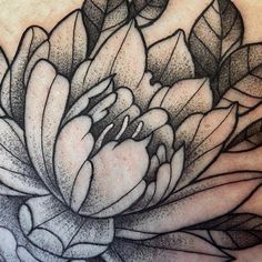 a black and white flower tattoo on the chest