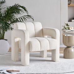 a white chair sitting on top of a rug next to a potted plant