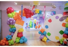 an art gallery with balloons and paintbrushes on the floor