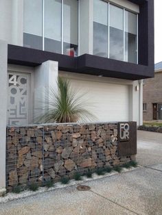 a modern house with stone and metal fence