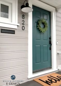 a blue front door with a green wreath on it's side and the words welcome