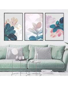 three paintings on the wall above a couch in a room with white walls and green furniture