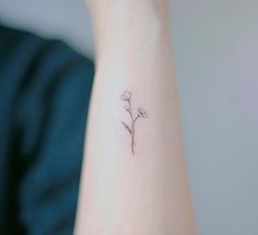 a small flower tattoo on the wrist